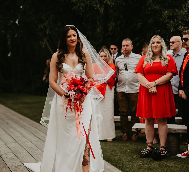 bride-walks-down-the-aisle-at-outdoor-wedding