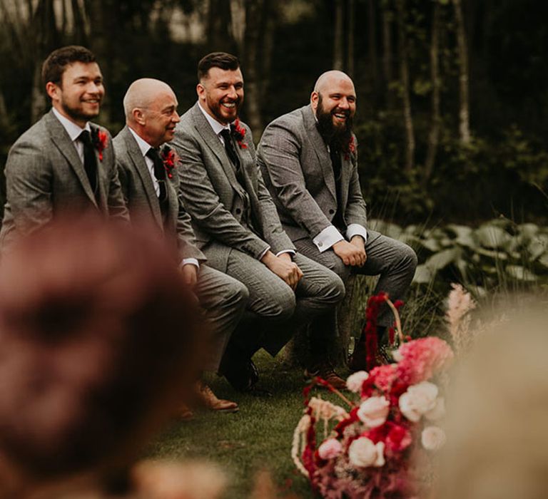 groomsmen-in-grey-wedding-suits-watching-celebrant-ceremony