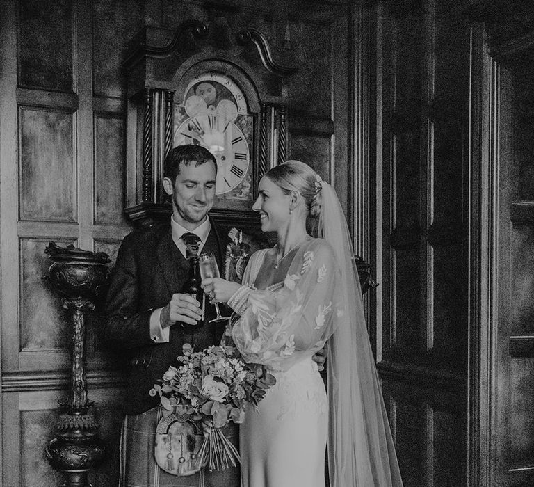 black-and-white-wedding-photo-bride-and-groom-hold-champagne-glasses