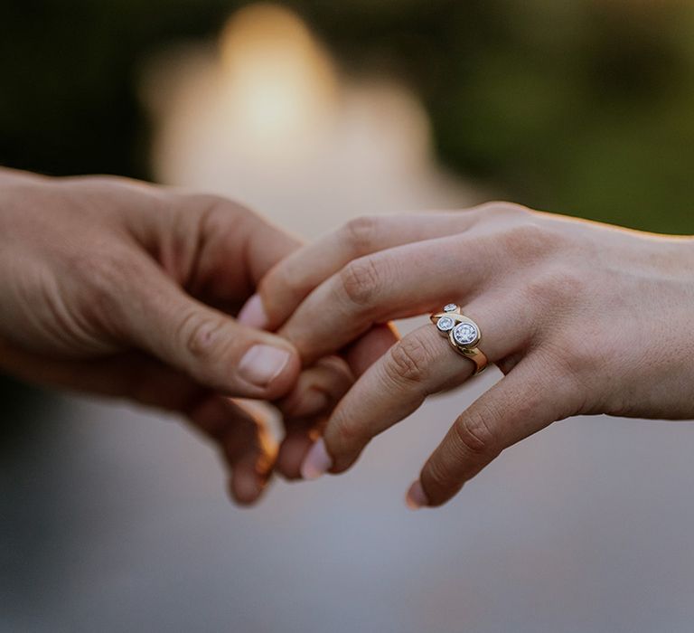 bride-and-groom-holding-hands-with-gold-diamond-wedding-ring