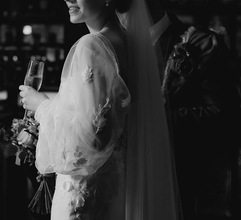 bride-wearing-sheer-sleeve-wedding-dress-with-veil.