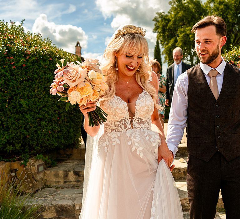 bride-in-madi-lane-wedding-dress-walking-hand-in-hand-with-groom