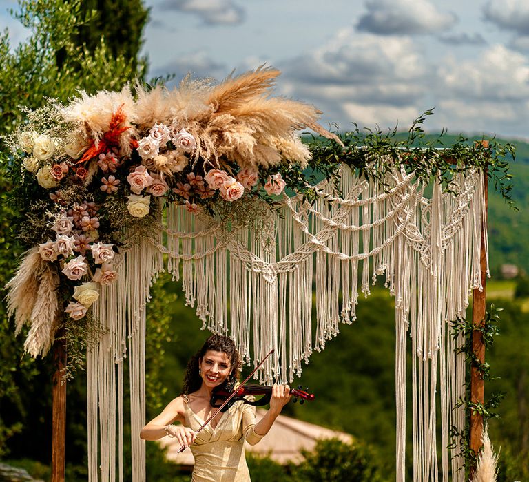 violin-playing-at-wedding-ceremony-with-macrame-altar-decorations