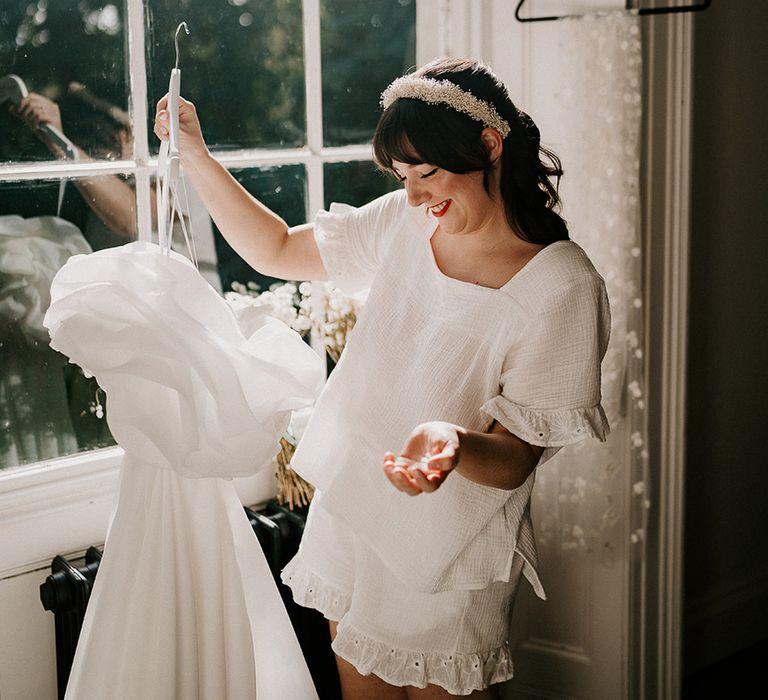 bride-wearing-matching-pyjama-set-holding-wedding-dress