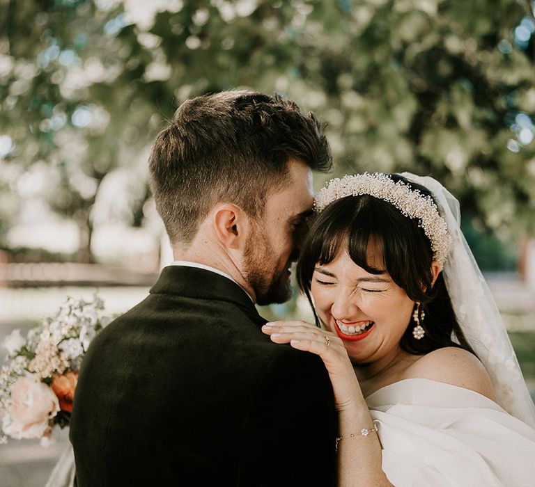 groom-embraces-bride-for-romantic-photo-with-bride-wearing-pearl-headband