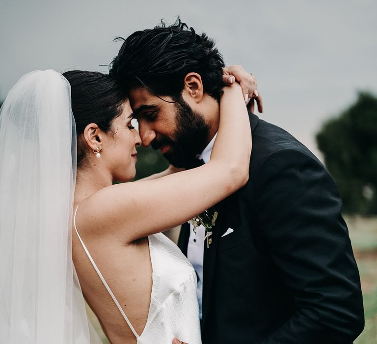 bride-in-low-back-satin-wedding-dress-embracing-groom