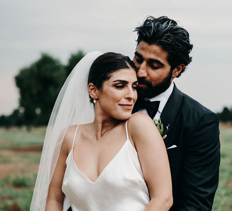 persian-wedding-with-bride-in-satin-wedding-dress-being-embraced-by-groom