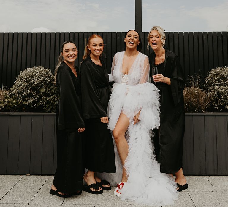 bridal-party-wearing-black-robes-and-bride-in-white-tulle-robe