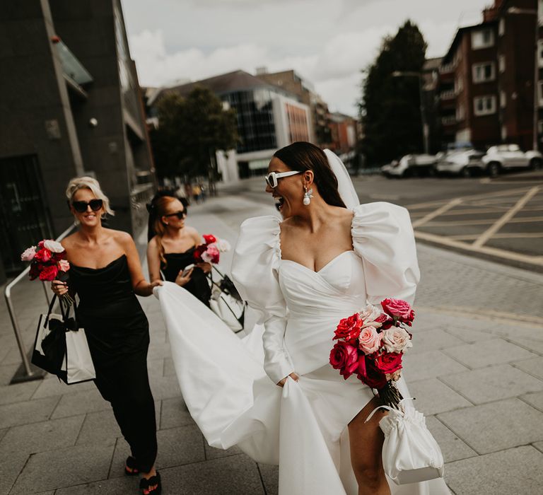 bride-wearing-puff-sleeve-wedding-dress-walking-with-bridal-party-in-black-bridesmaid-dresses