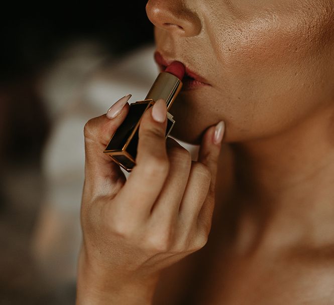 statement-bridal-earrings-with-bride-putting-on-lipstick