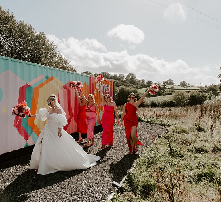 bride-walks-with-bridesmaids-in-colourful-dresses