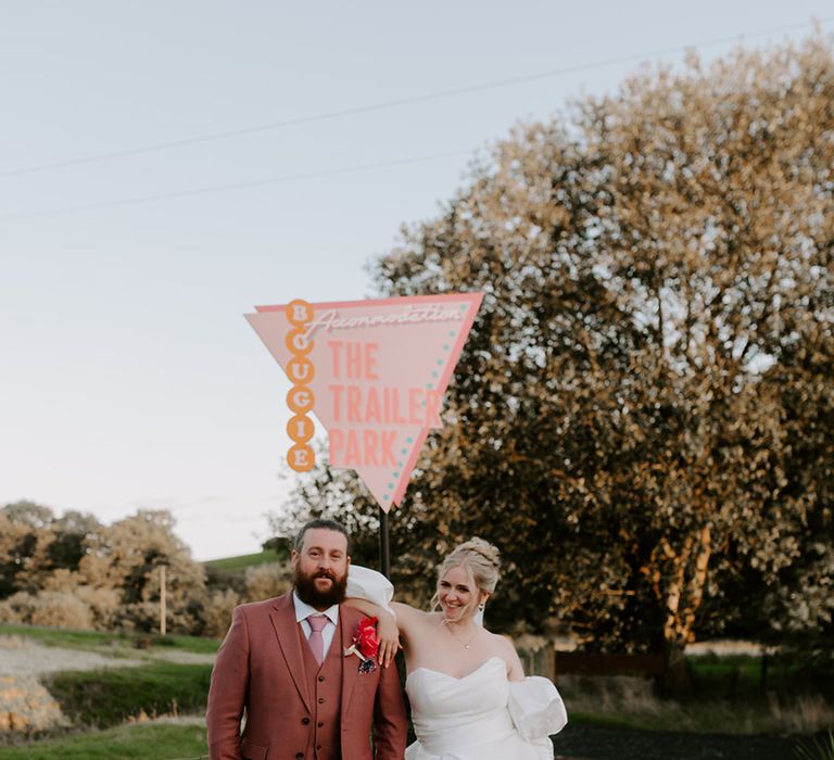 bride-wearing-front-slit-wedding-dress-with-red-garter-with-groom-in-pink-suit