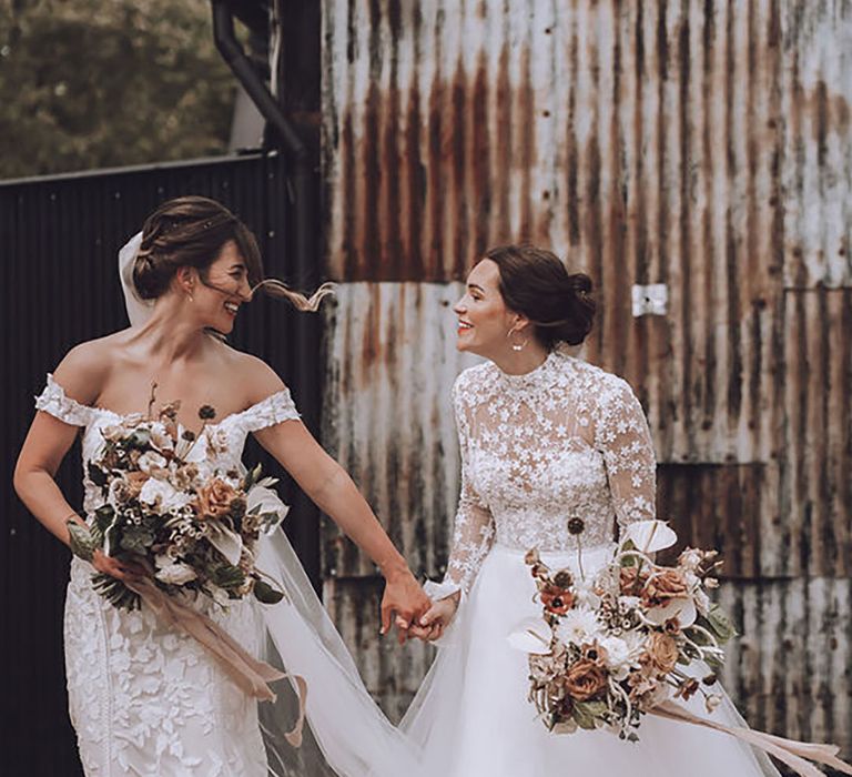 two brides on their wedding day wearing off-shoulder and high neck lace wedding dresses