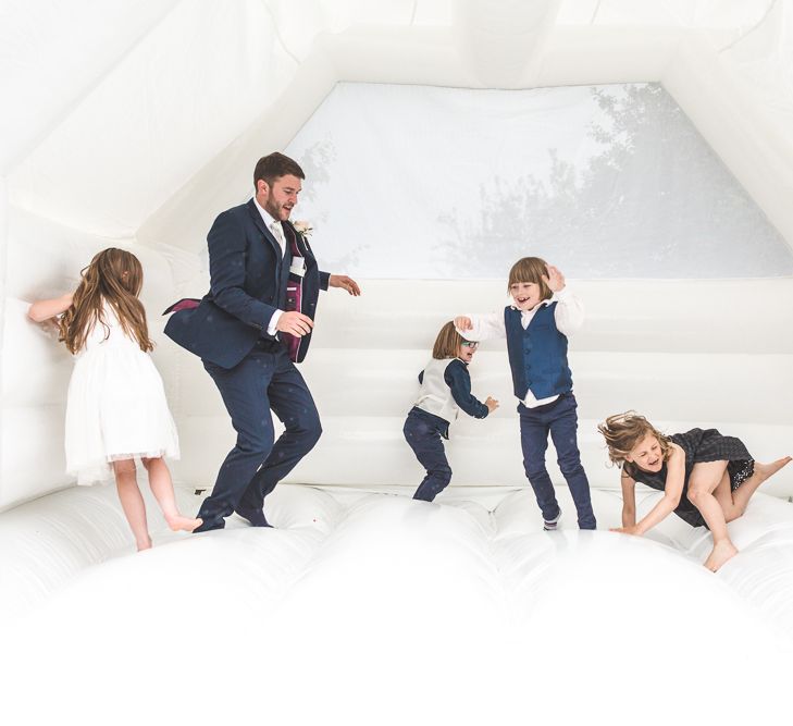 Groom & Miniature Wedding Guests on the Bouncy Castle