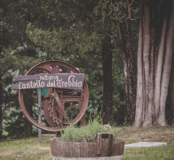 Outdoor Wedding Ceremony in Tuscany With Bright Florals And Rustic Wooden Seating