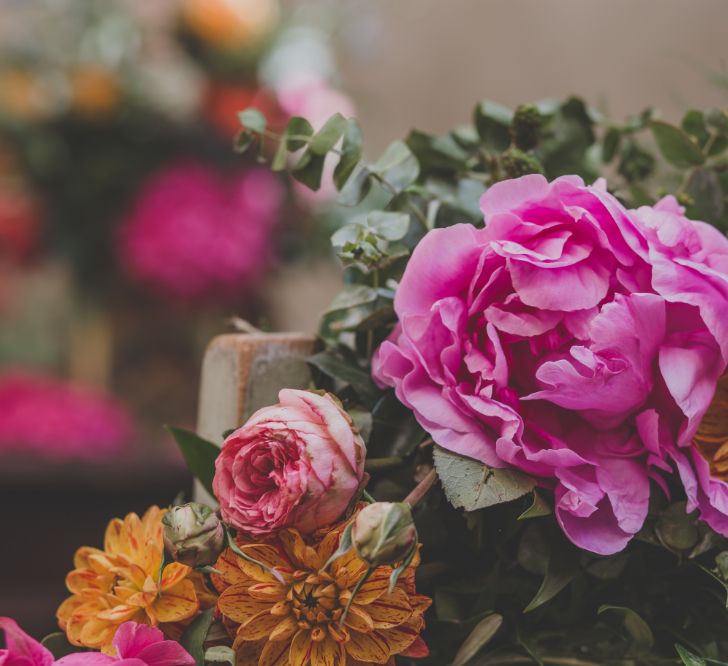 Outdoor Wedding Ceremony in Tuscany With Bright Florals And Rustic Wooden Seating