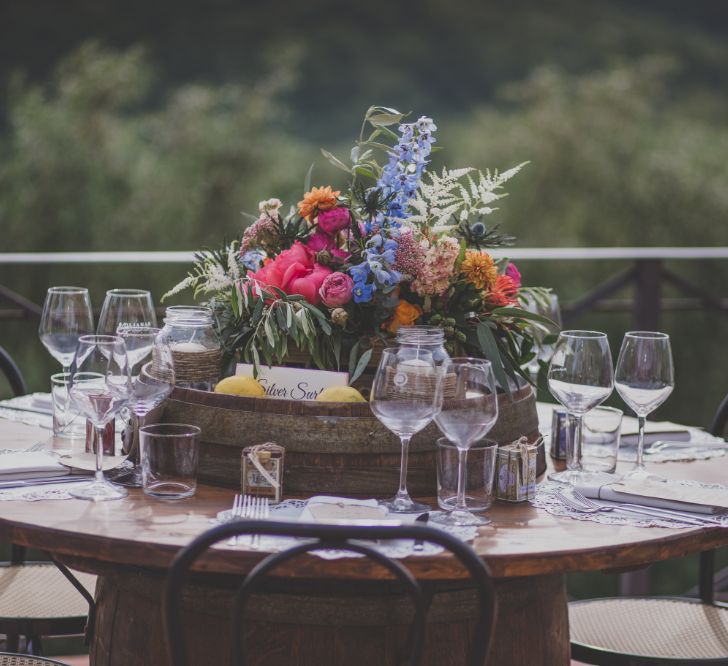 Outdoor Wedding Ceremony in Tuscany With Bright Florals And Rustic Wooden Seating