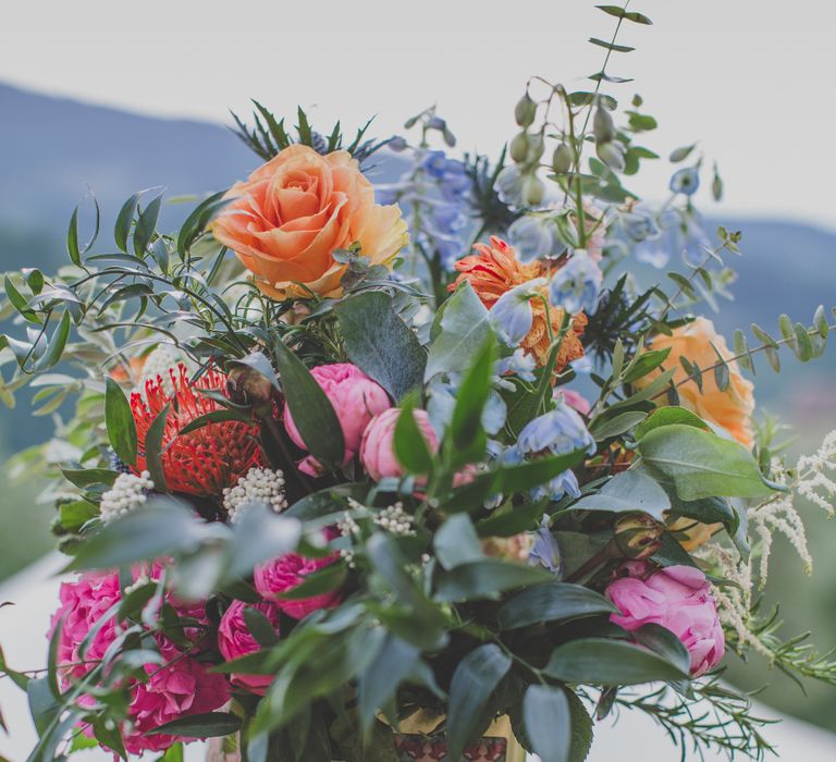 Outdoor Wedding Ceremony in Tuscany With Bright Florals And Rustic Wooden Seating