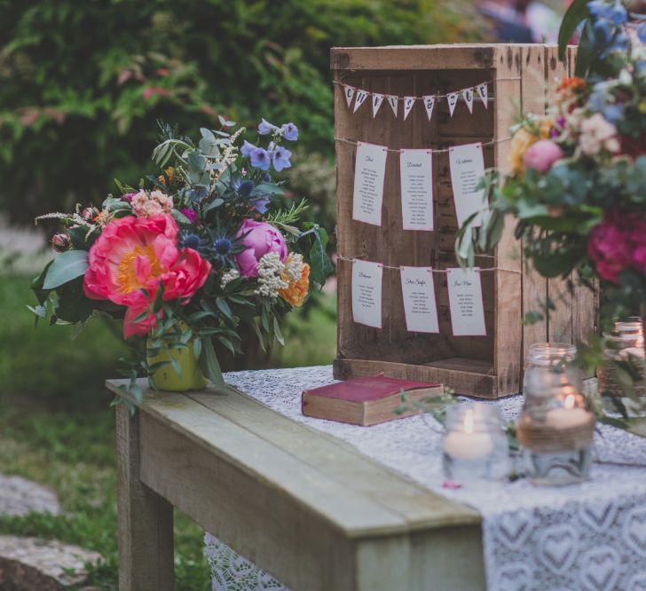 Outdoor Wedding Ceremony in Tuscany With Bright Florals And Rustic Wooden Seating