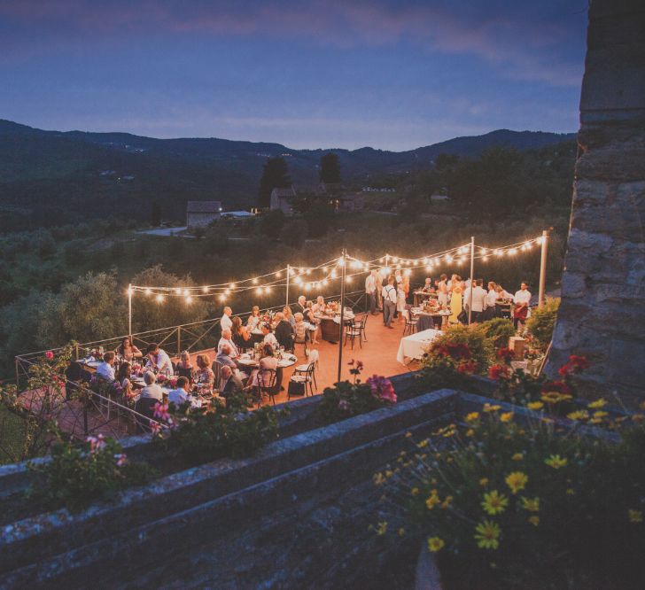 Outdoor Wedding Ceremony in Tuscany With Bright Florals And Rustic Wooden Seating