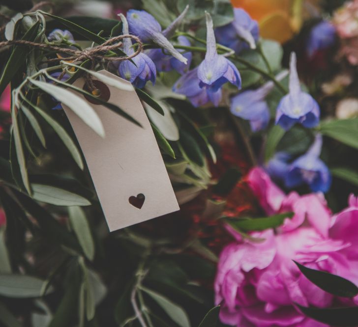 Outdoor Wedding Ceremony in Tuscany With Bright Florals And Rustic Wooden Seating