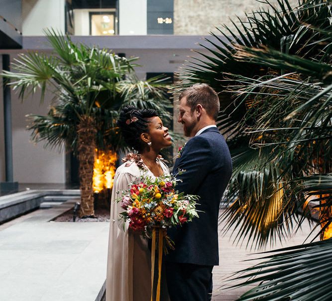 Bride in Bespoke Ailsa Monroe Jumpsuit & Cape | Groom in Next Navy Wool Suit | Relaxed Industrial Wedding at Ocean Studios, Plymouth | Freckle Photography