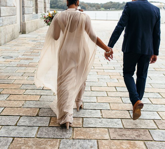 Bride in Bespoke Ailsa Monroe Jumpsuit & Cape | Groom in Next Navy Wool Suit | Relaxed Industrial Wedding at Ocean Studios, Plymouth | Freckle Photography