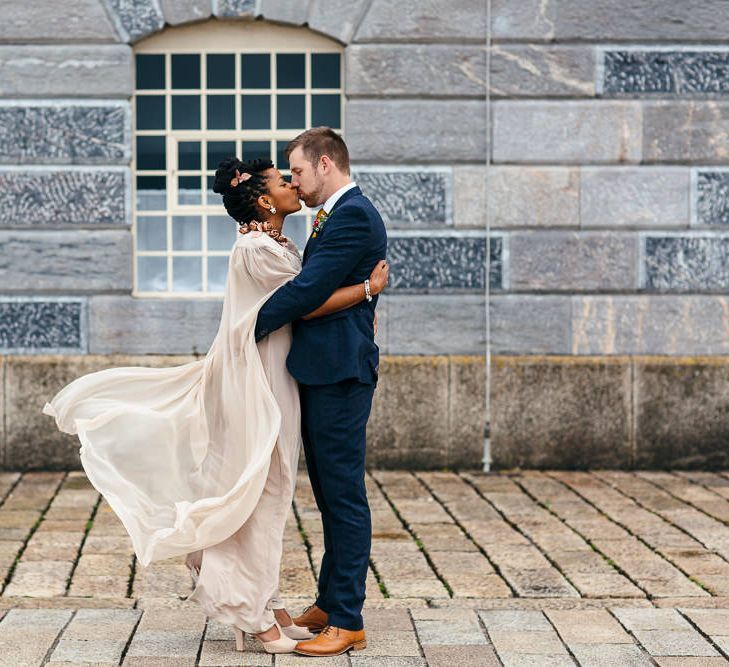 Bride in Bespoke Ailsa Monroe Jumpsuit & Cape | Groom in Next Navy Wool Suit | Relaxed Industrial Wedding at Ocean Studios, Plymouth | Freckle Photography