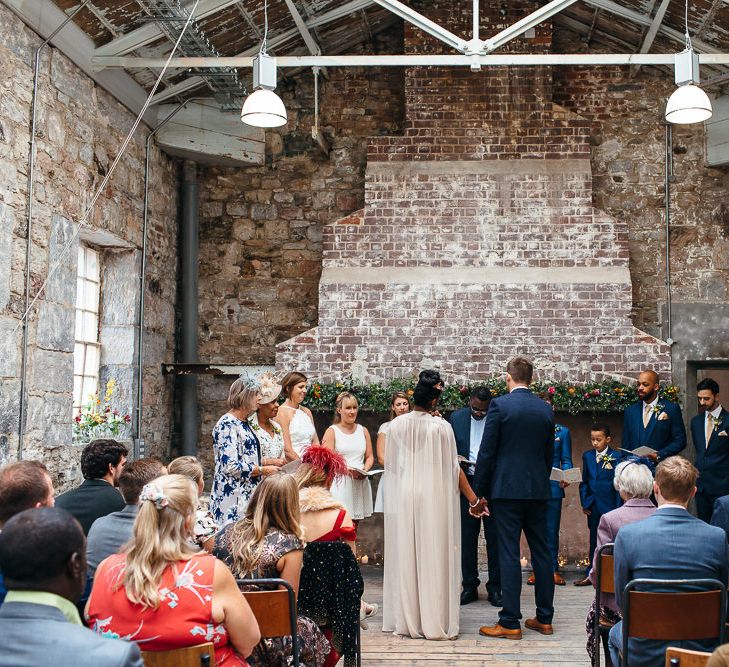 Wedding Ceremony | Bride in Bespoke Ailsa Monroe Jumpsuit & Cape | Groom in Next Navy Wool Suit | Relaxed Industrial Wedding at Ocean Studios, Plymouth | Freckle Photography