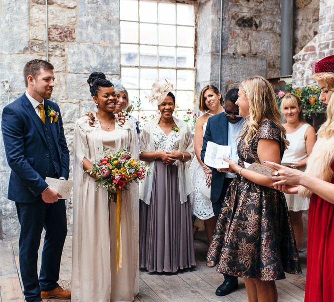 Wedding Ceremony | Bride in Bespoke Ailsa Monroe Jumpsuit & Cape | Groom in Next Navy Wool Suit | Relaxed Industrial Wedding at Ocean Studios, Plymouth | Freckle Photography