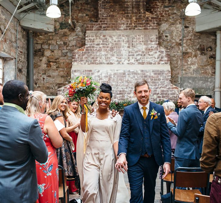 Wedding Ceremony | Bride in Bespoke Ailsa Monroe Jumpsuit & Cape | Groom in Next Navy Wool Suit | Relaxed Industrial Wedding at Ocean Studios, Plymouth | Freckle Photography