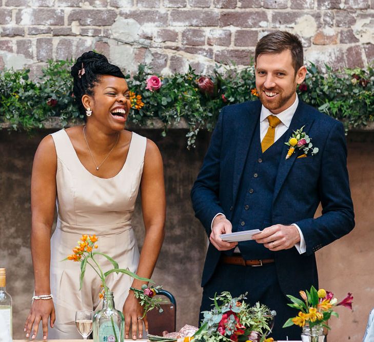 Wedding Speeches | Bride in Bespoke Ailsa Monroe Jumpsuit & Cape | Groom in Next Navy Wool Suit | Relaxed Industrial Wedding at Ocean Studios, Plymouth | Freckle Photography