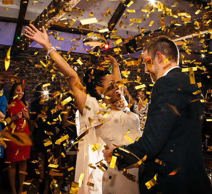 Confetti Bomb | Bride in Bespoke Ailsa Monroe Jumpsuit & Cape | Groom in Next Navy Wool Suit | Relaxed Industrial Wedding at Ocean Studios, Plymouth | Freckle Photography