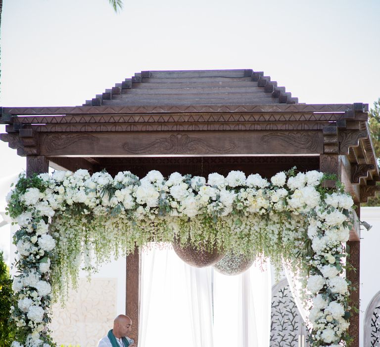 Flower Covered Arbour | Bride in Suzanne Neville Wedding Dress | Groom in Reiss Suit | Outdoor Ibiza Destination Wedding | Gypsy Westwood Photography | Infin8 Film