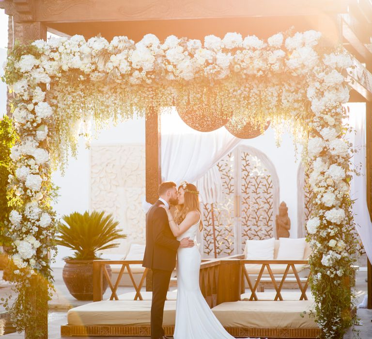 Floral Arbour | Bride in Suzanne Neville Wedding Dress | Groom in Reiss Suit | Outdoor Ibiza Destination Wedding | Gypsy Westwood Photography | Infin8 Film