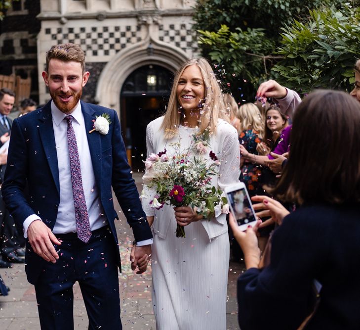 Confetti Exit | Bride in Pleats Please Issey Miyak Dress | Groom in Beggars Run Suit | Chic London Wedding at St Bartholomew the Great Church & St John Bar & Restaurant | Helen Abraham Photography