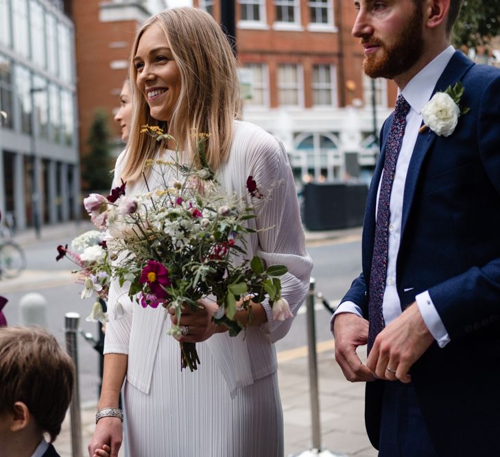 Bride in Pleats Please Issey Miyak Dress | Groom in Beggars Run Suit | Chic London Wedding at St Bartholomew the Great Church & St John Bar & Restaurant | Helen Abraham Photography