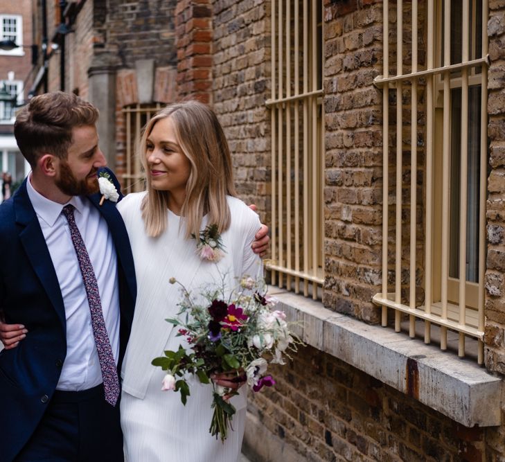 Bride in Pleats Please Issey Miyak Dress | Groom in Beggars Run Suit | Chic London Wedding at St Bartholomew the Great Church & St John Bar & Restaurant | Helen Abraham Photography