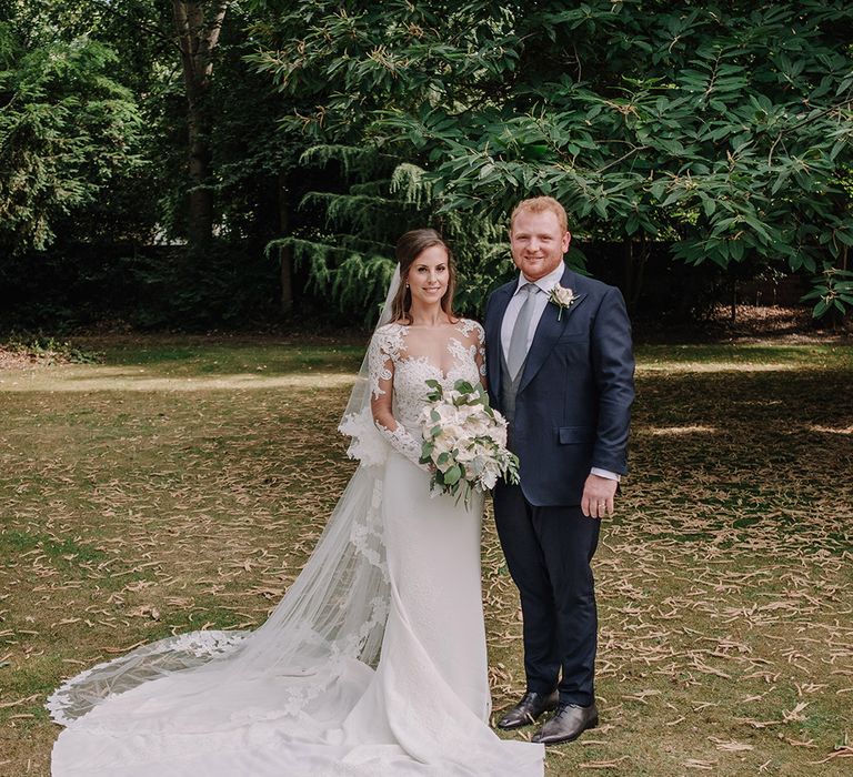 Bride in Lace Pronovias Bridal Gown | Groom in Thom Sweeney Suit | White and Silver English Country Garden At Home Marquee Wedding | Jason Mark Harris Photography