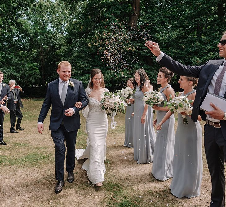 Confetti Exit | Bride in Lace Pronovias Bridal Gown | Groom in Thom Sweeney Suit | White and Silver English Country Garden At Home Marquee Wedding | Jason Mark Harris Photography