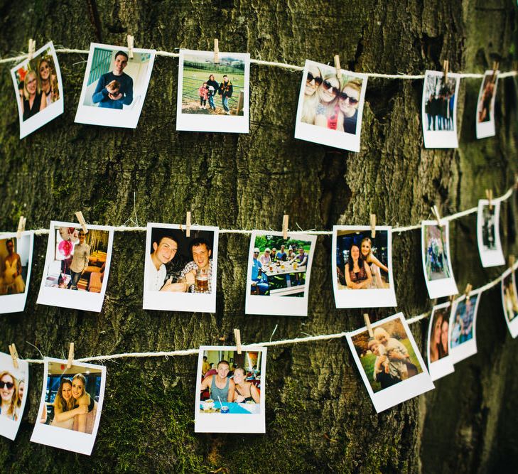 Polaroid Pictures strung up around a tree trunk