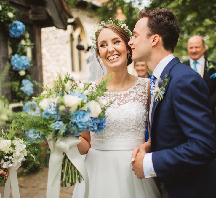 Bride in Lace Bodice & Ingrida Bridal Wedding Dress with Blue & White Hydrangea & Stock Bouquet and Groom in Traditional Morning Suit