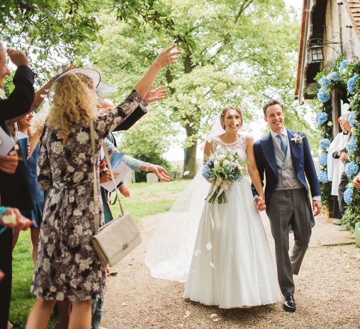 Bride in Lace Bodice & Ingrida Bridal Wedding Dress with Blue & White Hydrangea & Stock Bouquet and Groom in Traditional Morning Suit