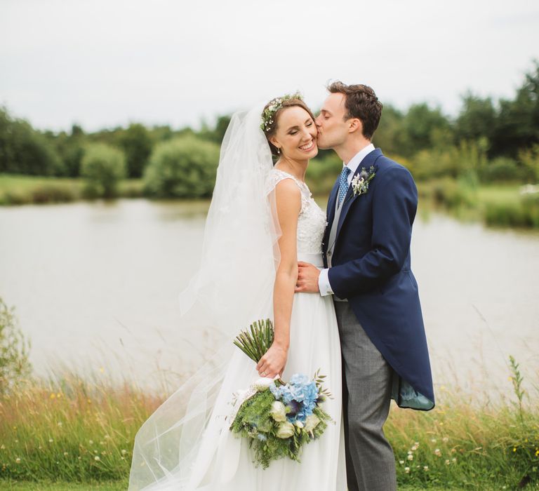 Bride in Lace Bodice & Ingrida Bridal Wedding Dress with Blue & White Hydrangea & Stock Bouquet and Groom in Traditional Morning Suit