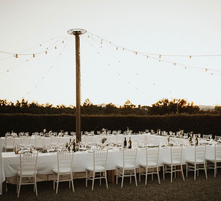 Outdoor Dining At Destination Wedding With Festoon Lights // Elegant Destination Wedding In Tuscany At San Galgano Abbey With Bride In Bespoke Dress By Madame Paulette With Images From James Frost Photography