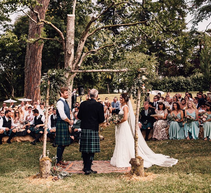 Wedding Ceremony | Bride in Lace Yolan Cris Gown | Groom in Tartan Kilt | Outdoor Destination Wedding at Château De Malliac Planned by Country Weddings in France | Styling by The Hand-Painted Bride | Samuel Docker Photography | Marriage in Motion Films