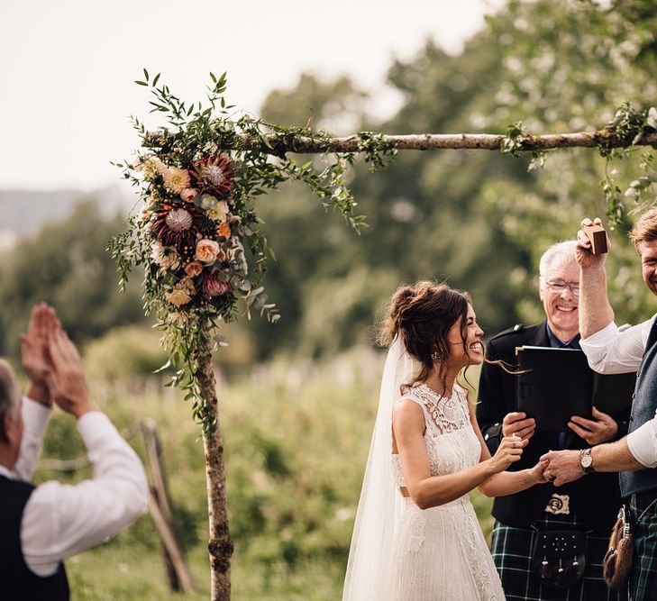 Wedding Ceremony | Floral Altar | Bride in Lace Yolan Cris Gown | Groom in Tartan Kilt | Outdoor Destination Wedding at Château De Malliac Planned by Country Weddings in France | Styling by The Hand-Painted Bride | Samuel Docker Photography | Marriage in Motion Films