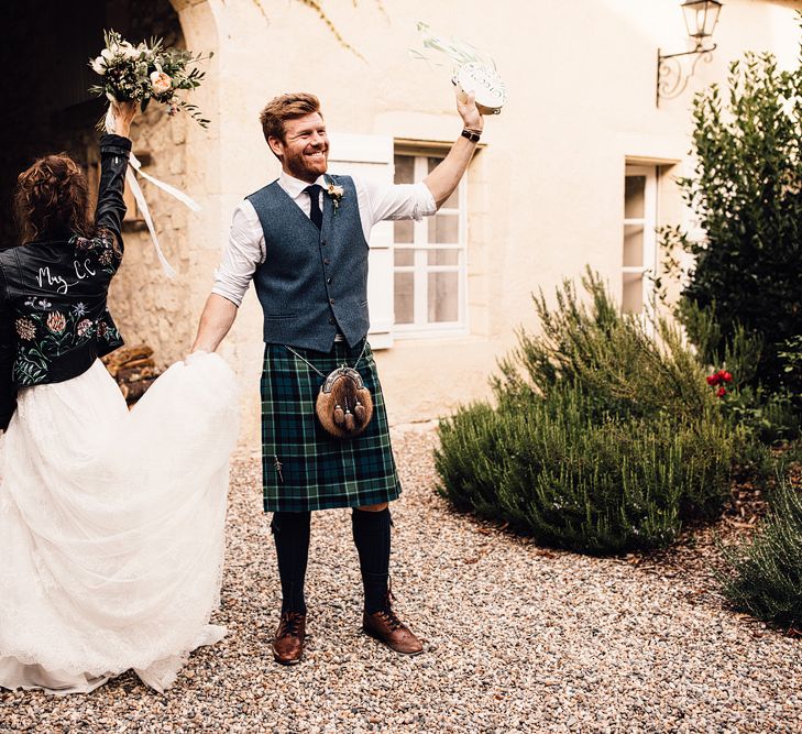 Bride in Yolan Cris Lace Gown & Leather Jacket | Groom in Tartan Kilt | Outdoor Destination Wedding at Château De Malliac Planned by Country Weddings in France | Styling by The Hand-Painted Bride | Samuel Docker Photography | Marriage in Motion Films