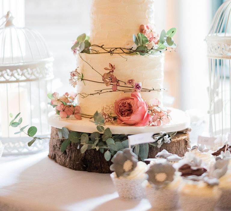 Iced Wedding Cake & Coral Decor on Tree Stump Cake Stand | Romantic Peach & Coral Floral Centrepiece | Peach & Coral Country Wedding at Crabbs Barn, Essex | Kathryn Hopkins Photography | Film by Colbridge Media Services Ltd