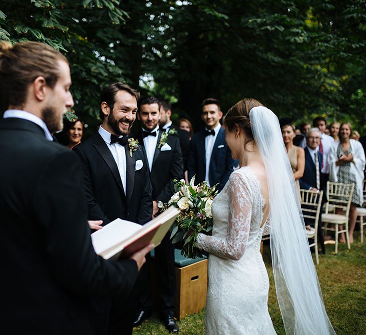 Outdoor Wedding Ceremony at Childerley Hall | Bride in Lace Sottero & Midgley Gown | Groom in Herrvon Eden Tuxedo | Tawny Photo